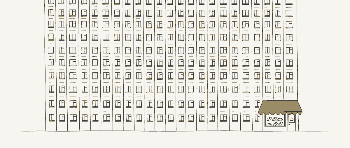 Une tour d'habitation immense aux fenêtres toutes identiques, et à son pied une minuscule boulangerie sous un auvent.