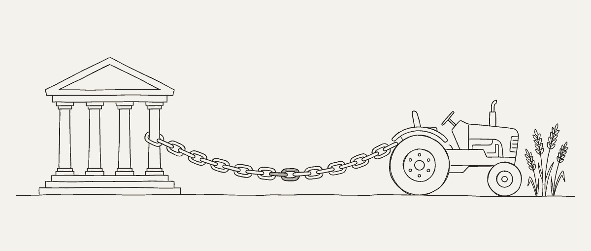 Une banque à colonnes reliée à un tracteur par une lourde chaîne qui pend entre les deux. Derrière le tracteur, quelques épis de blé.